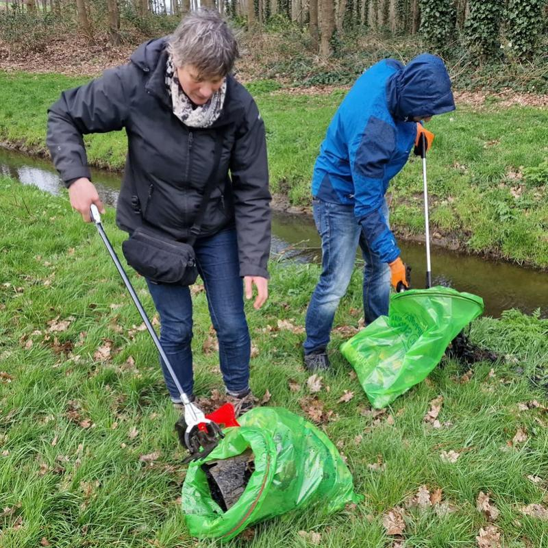 Twee mensen die afval oprapen