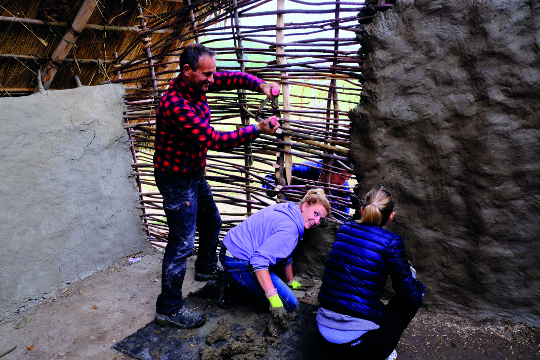 De vlechtwerkwand van het Rotta-huis wordt dichtgesmeerd met klei (foto Archeologie Rotterdam 2019)