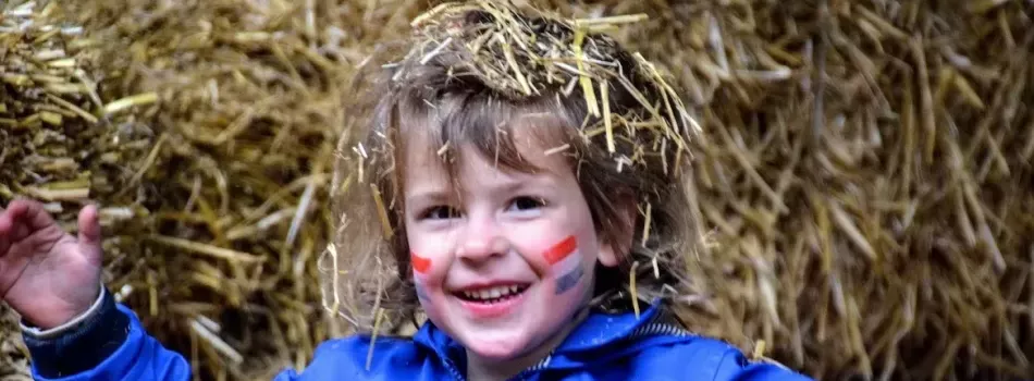 Blij jongetje vanwege leuke Koningsdag activiteiten.